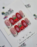 A set of 10 press-on nails displayed on a branded card, featuring red and pink designs with white stripes, cherries, and green leaves, set against a white patterned background.